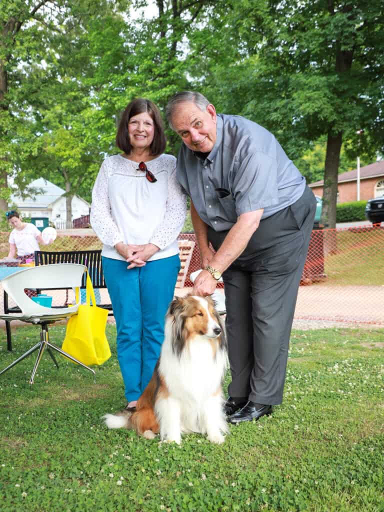 Hand in Paw volunteers pose with a dog at a volunteer appreciation event.