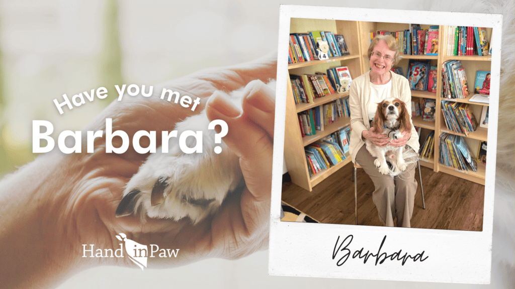Have you met Barbara? Hand in Paw therapy team member poses with her dog in a library.