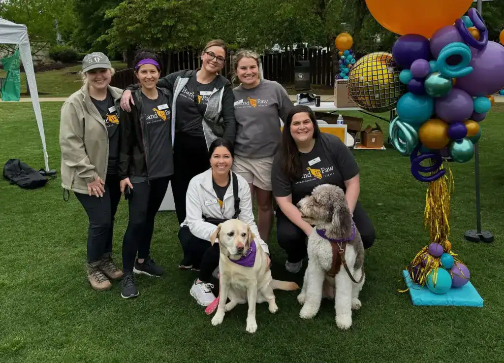 Hand in Paw junior board members pose with two dogs at Mutt Strut 2024.