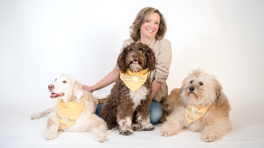 Stephanie Stoltzner with three therapy dogs for Hand in Paw's volunteer programs