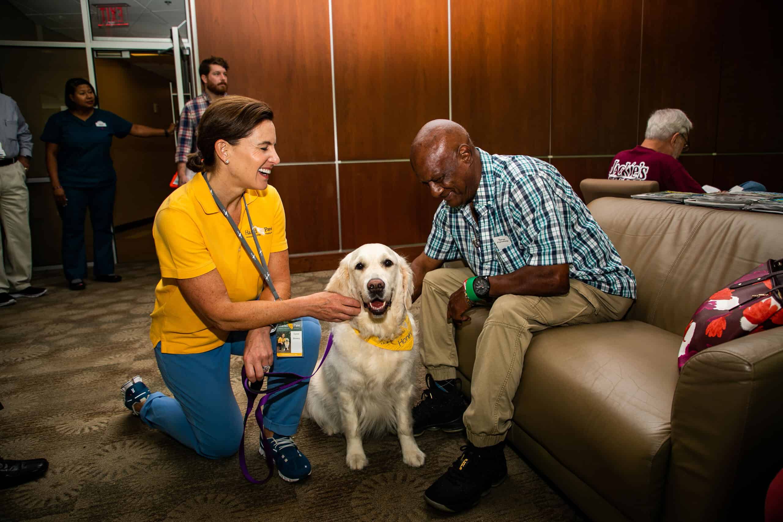 Hand in Paw volunteer and therapy dog bring comfort to a man in a care community.