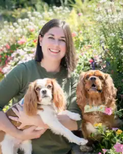 Brittany Filby poses with her dogs Chester and Cooper in the gardens at Hand in Paw