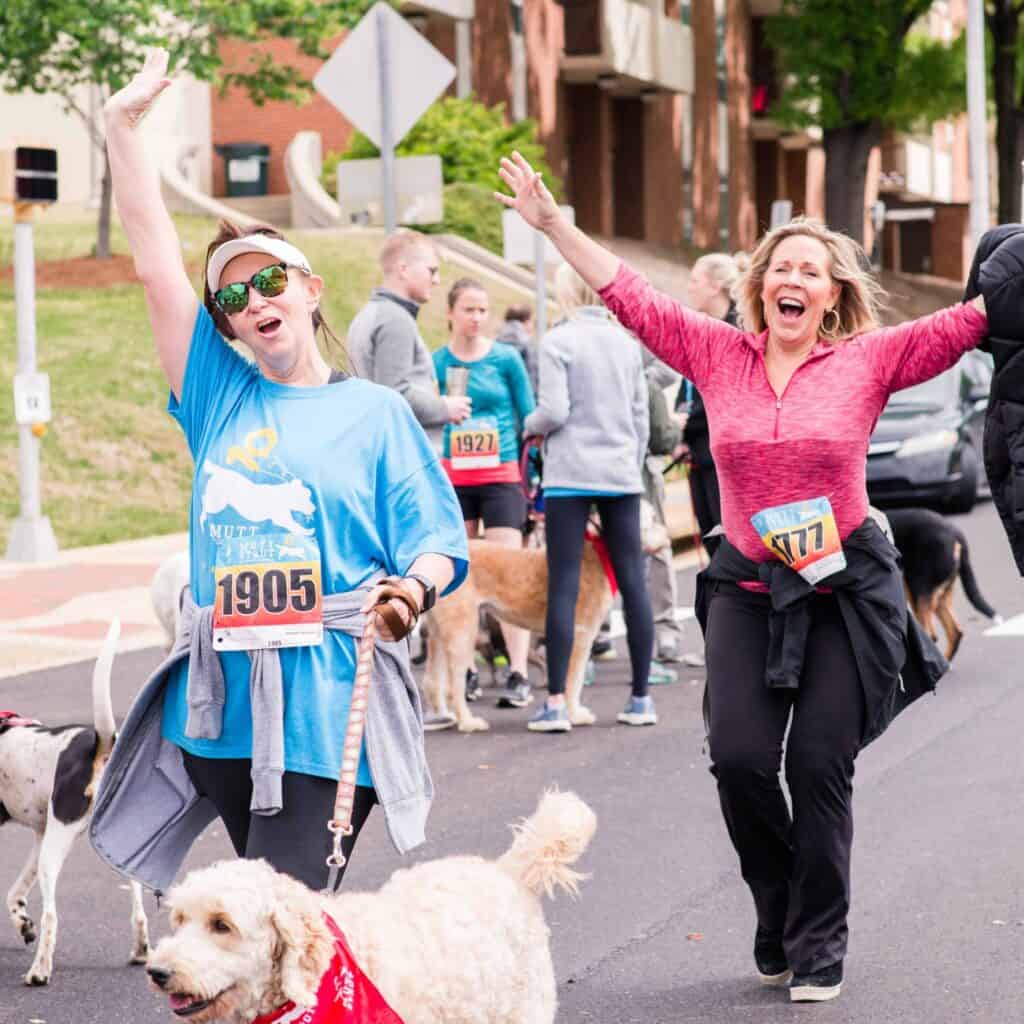 Hand in Paw volunteers and their dogs participate enthusiastically in a community charity race.