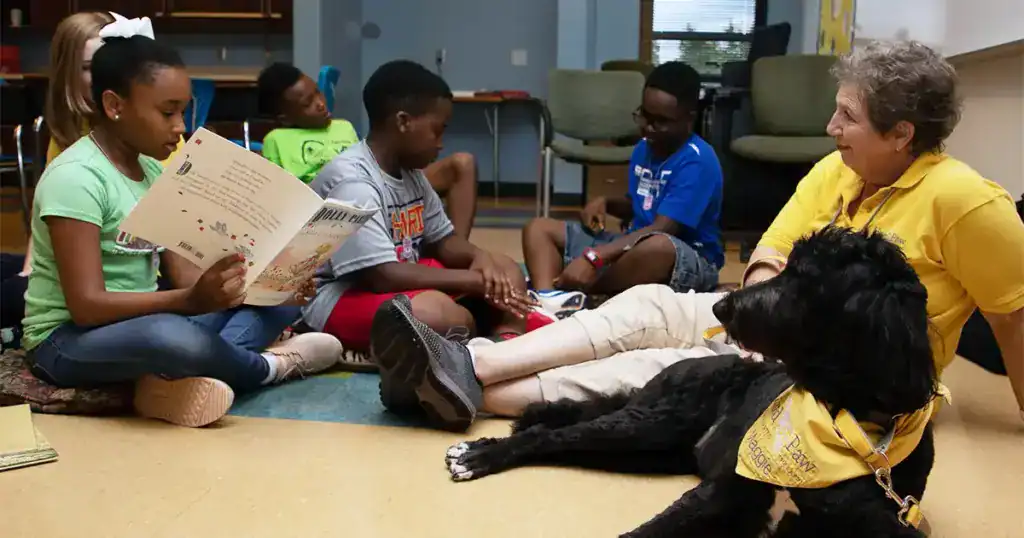 Therapy dog visits with children during an animal-assisted education session.