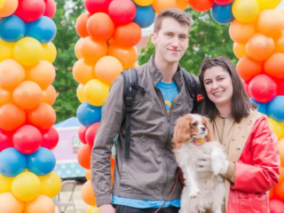 Mutt Strut 2019 Brittany and Cooper Filby pose with their dog Chester in front of balloons at Mutt Strut 2019.