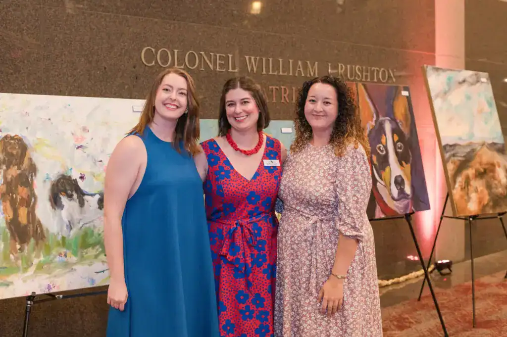 Guests, including Brittany Filby, pose in front of artwork at the 2022 Picasso Pets gala.