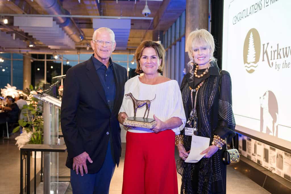 Hand in Paw supporters pose with an award at a recognition event.