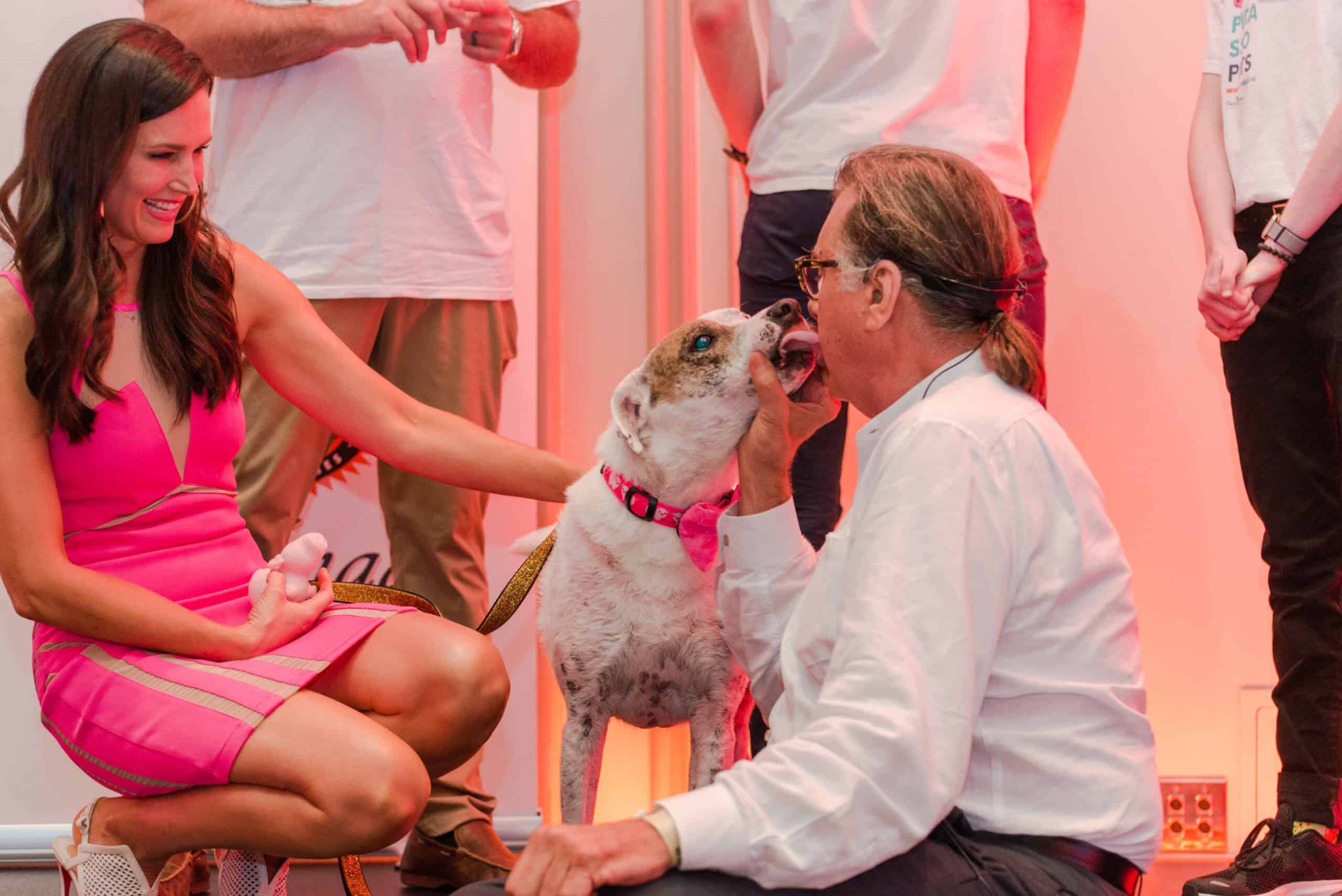 Danielle Yancey with her dog Trooper on stage at the Picasso Pets auction