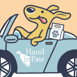 Hand in Paw logo featuring a smiling dog riding in a car.