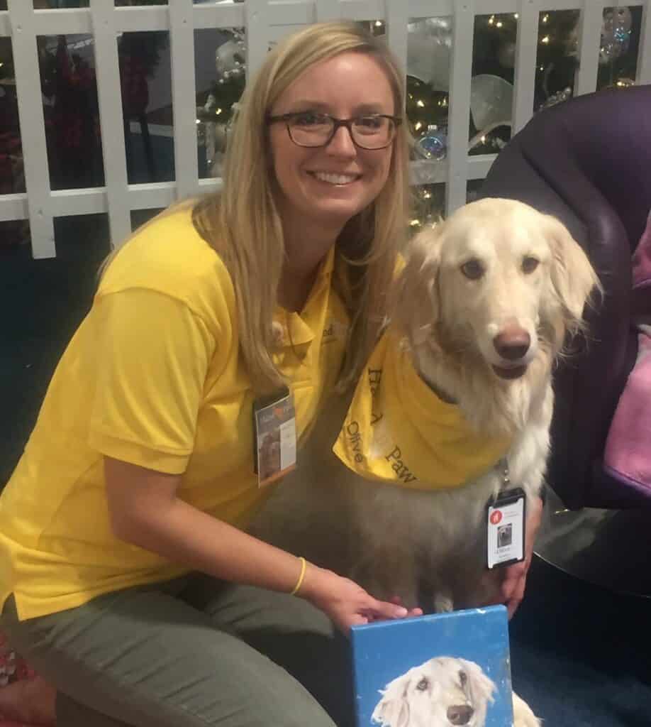 Hand in Paw volunteer and golden retriever Therapy Team wearing matching yellow shirts